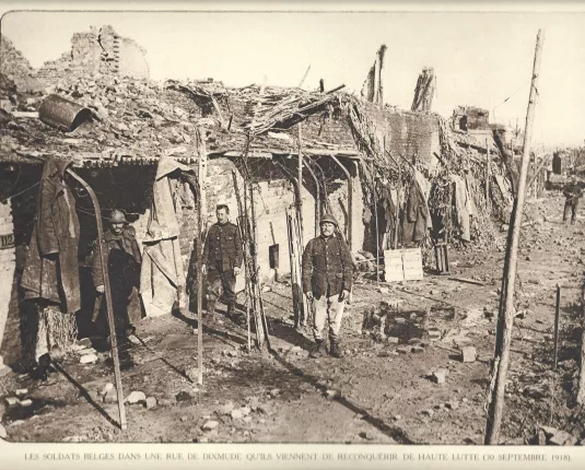 Les soldats belges dans une rue de Dixmude qu'ils viennent de reconquérir de haute lutte (30 Septembre 1918)